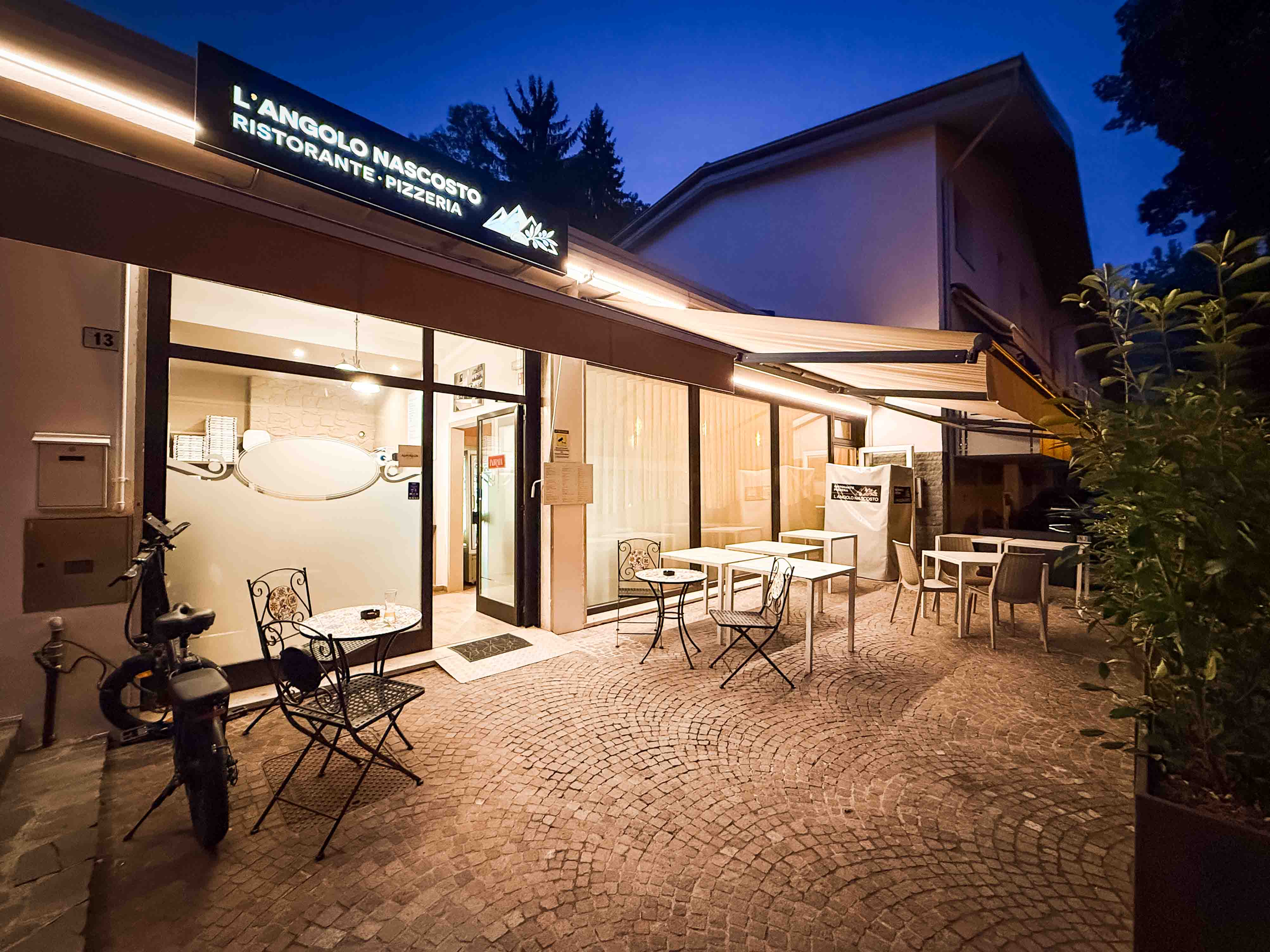 Esterno serale del ristorante con tavoli all'aperto